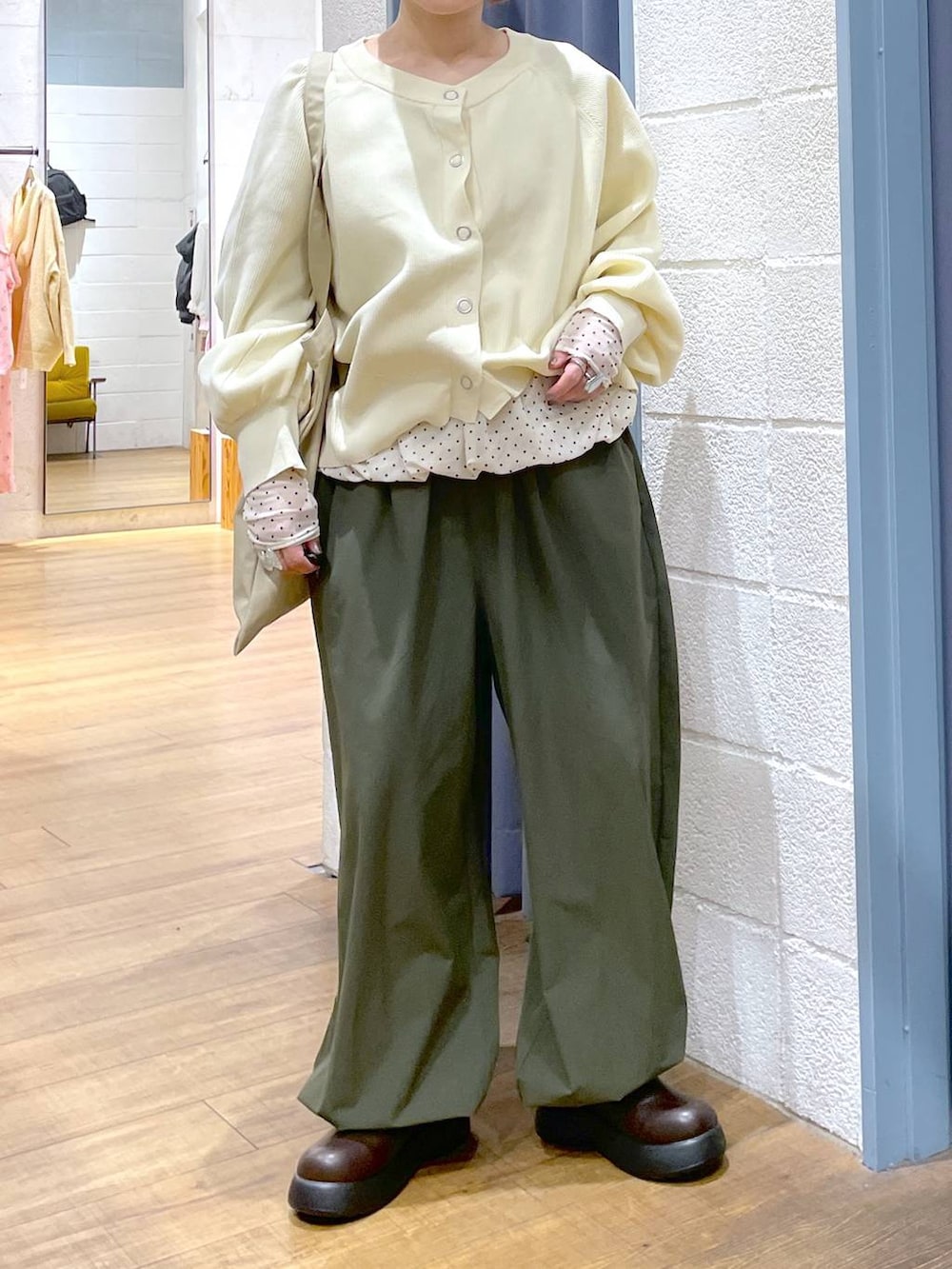 ベージュ系のトートバッグ、ブラウン系のサンダル、グリーン系のその他パンツを着用したレディースの冬コーディネートの3枚目の写真