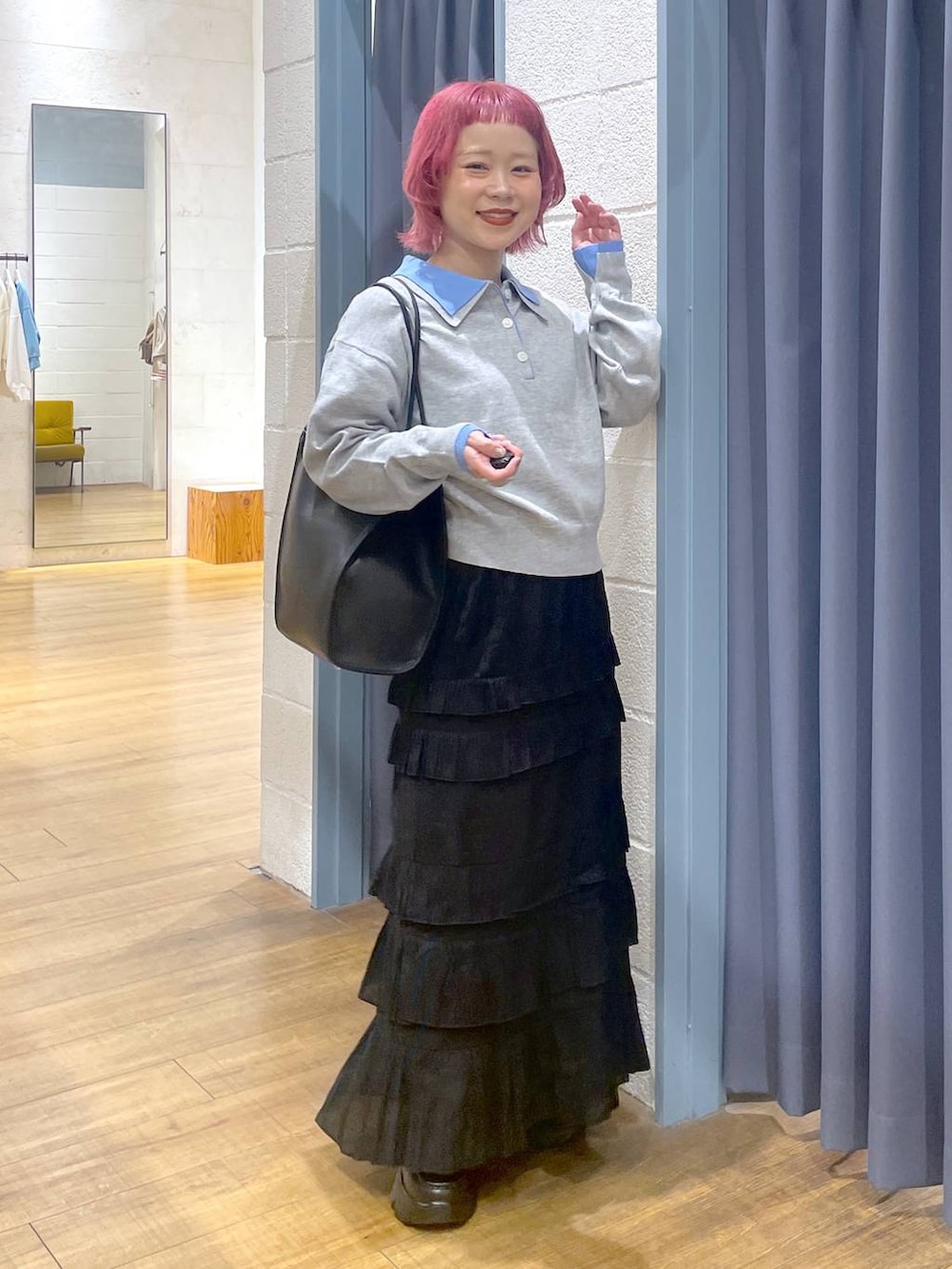 ブラック系のローファー、ブラック系のスカート、ブラック系のトートバッグを着用したレディースの春コーディネートの3枚目の写真