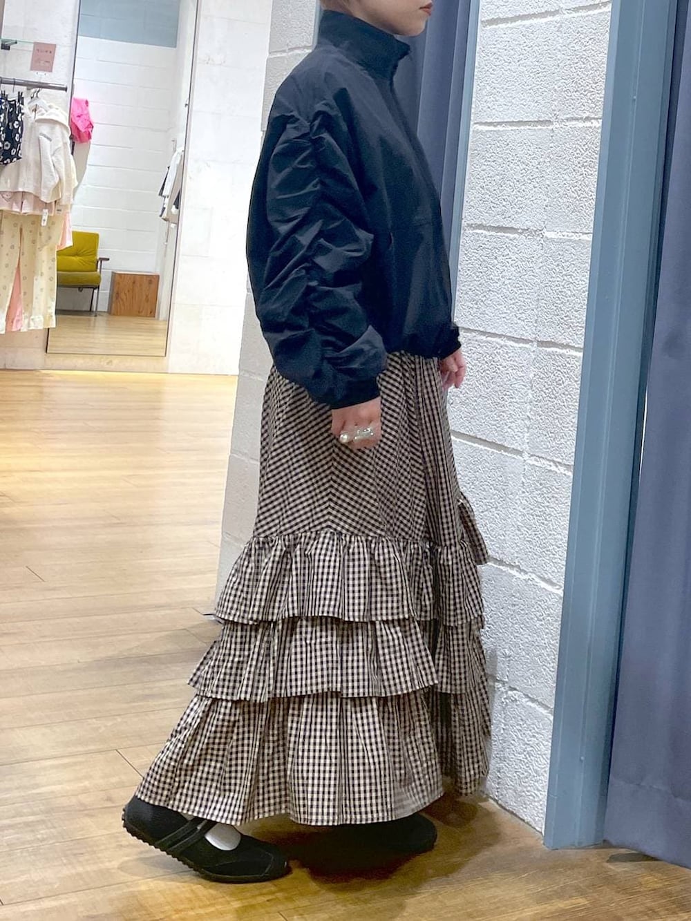 ブラック系のスニーカー、ブラック系のブルゾン、ブラウン系のスカートを着用したレディースの春コーディネートの3枚目の写真