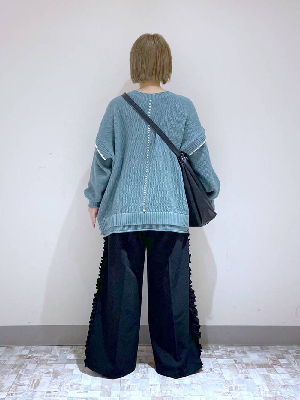 グリーン系のニット/セーター、ブラック系のローファー、ブラック系のその他パンツを着用したレディースの秋コーディネートの4枚目の写真