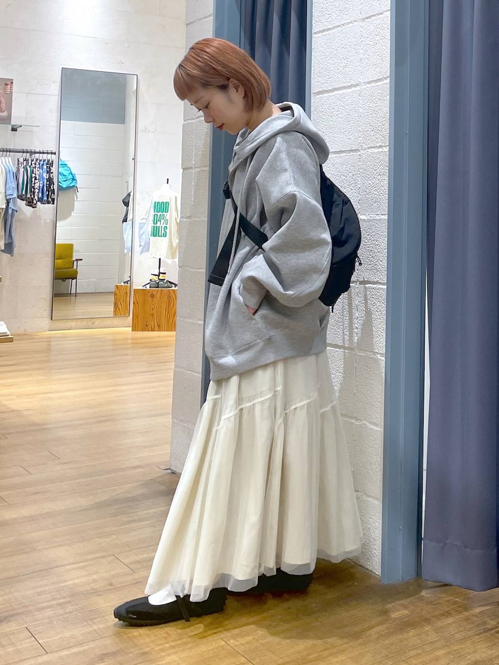 グレー系のパーカー、ブラック系のショルダーバッグ、ブラック系のスニーカーを着用したレディースの春コーディネートの2枚目の写真