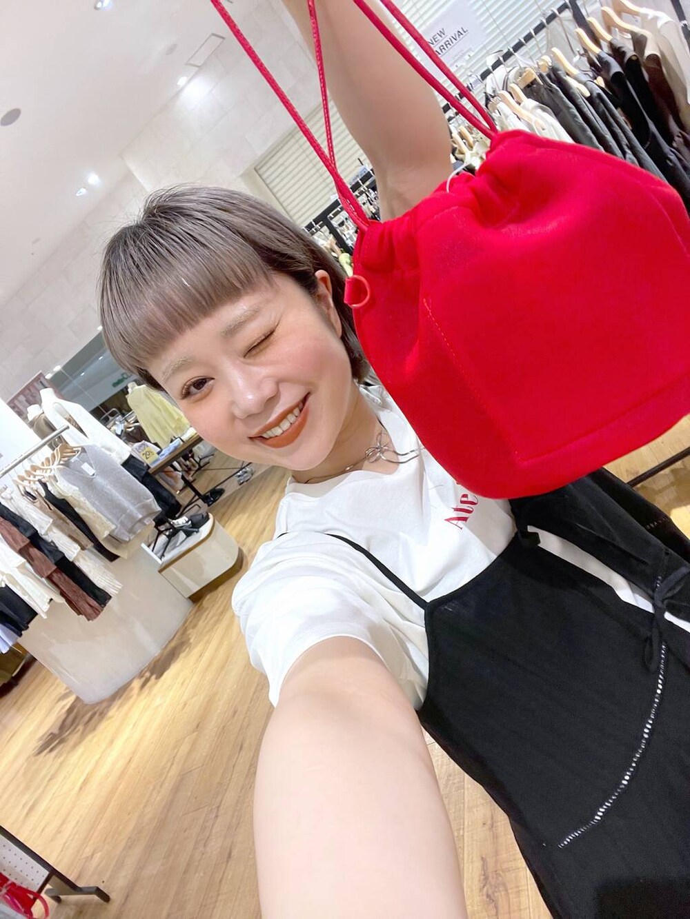 ホワイト系のTシャツ/カットソー、ブラック系のワンピース、シルバー系のネックレスを着用したレディースの春コーディネートの4枚目の写真