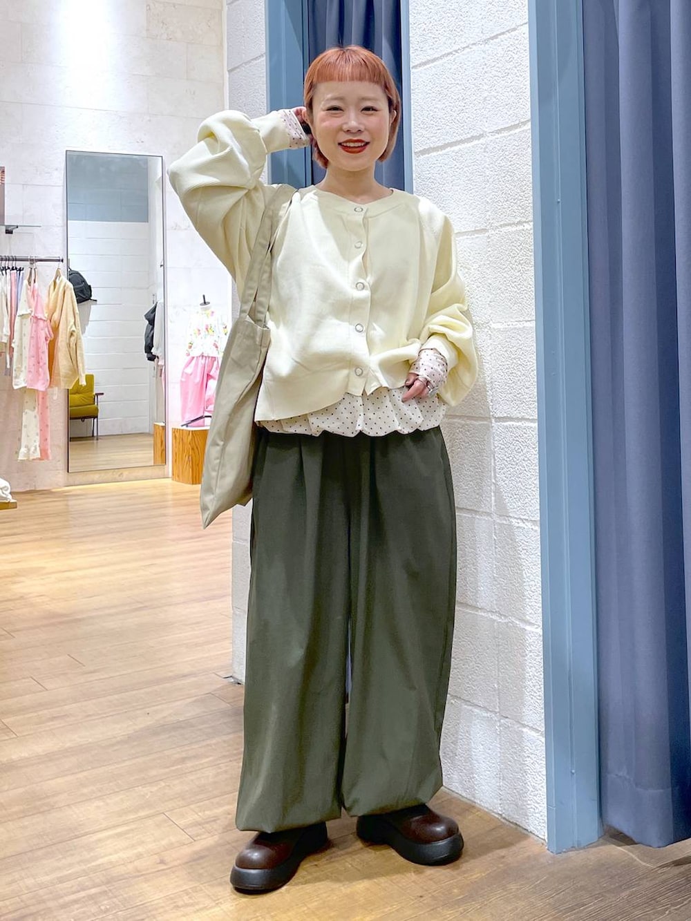 ベージュ系のトートバッグ、ブラウン系のサンダル、グリーン系のその他パンツを着用したレディースの冬コーディネートの2枚目の写真