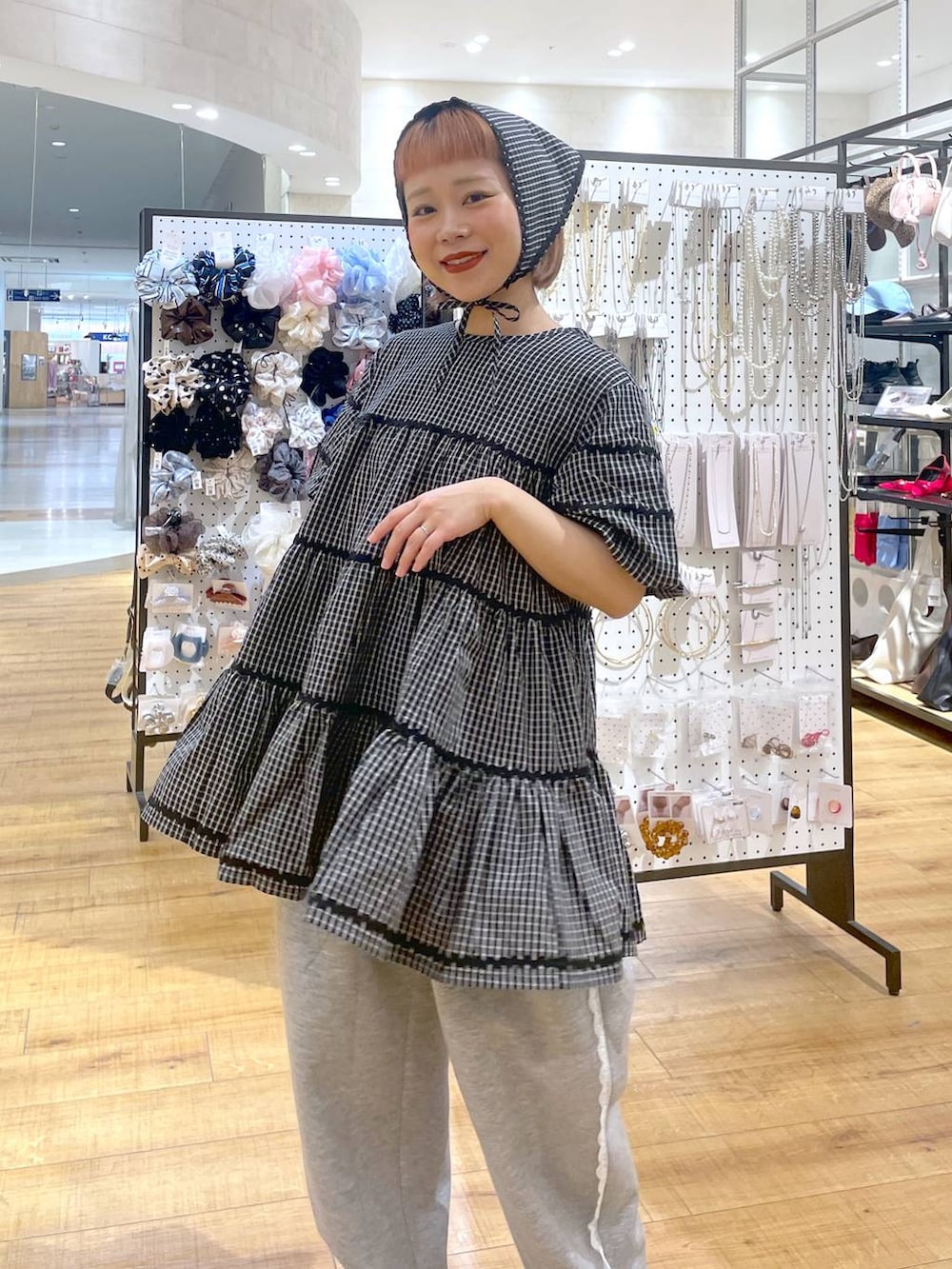 グレー系のスウェットパンツ、ホワイト系のワンピースを着用したレディースの春コーディネートの3枚目の写真