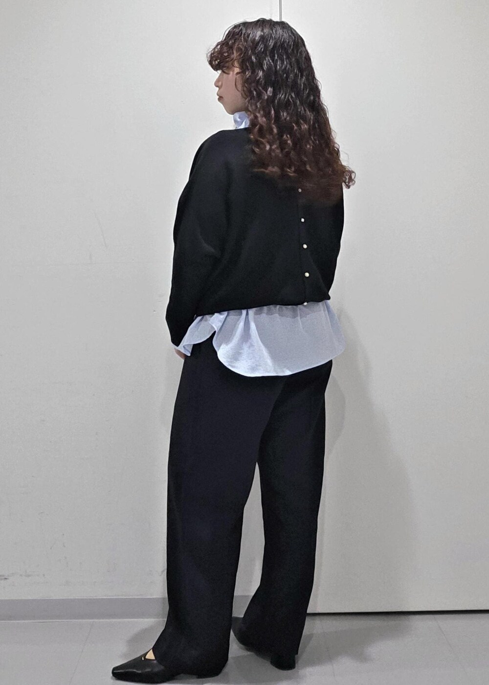 ブラック系のパンプス、ブラック系のニット/セーター、ブルー系のその他パンツを着用したレディースの冬コーディネートの6枚目の写真