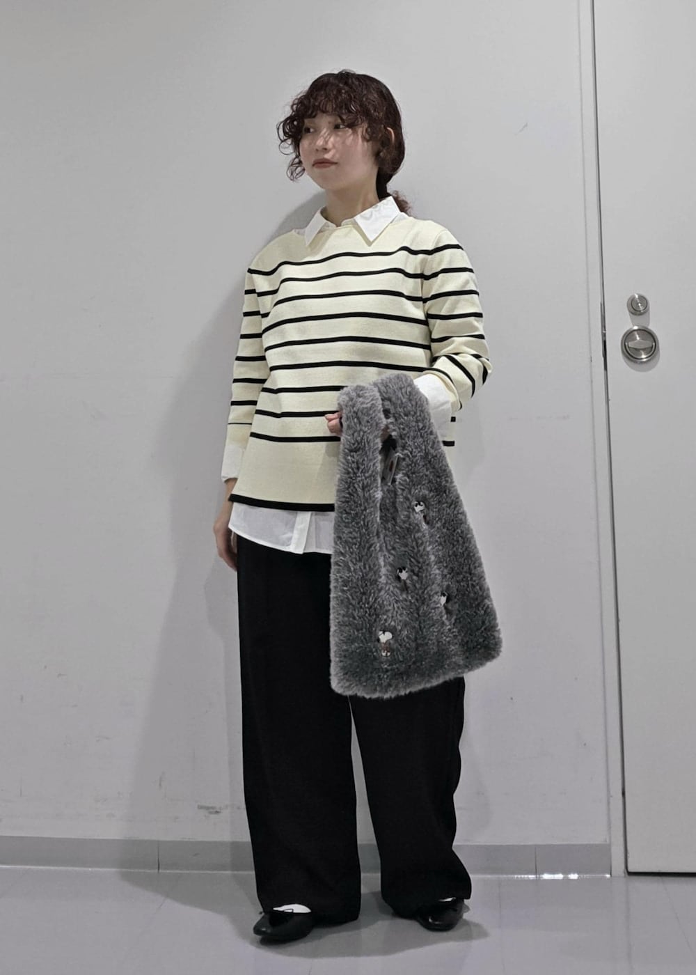 ホワイト系のシャツ/ブラウス、ホワイト系のニット/セーター、ブルー系のスラックスを着用したレディースの秋コーディネートの3枚目の写真