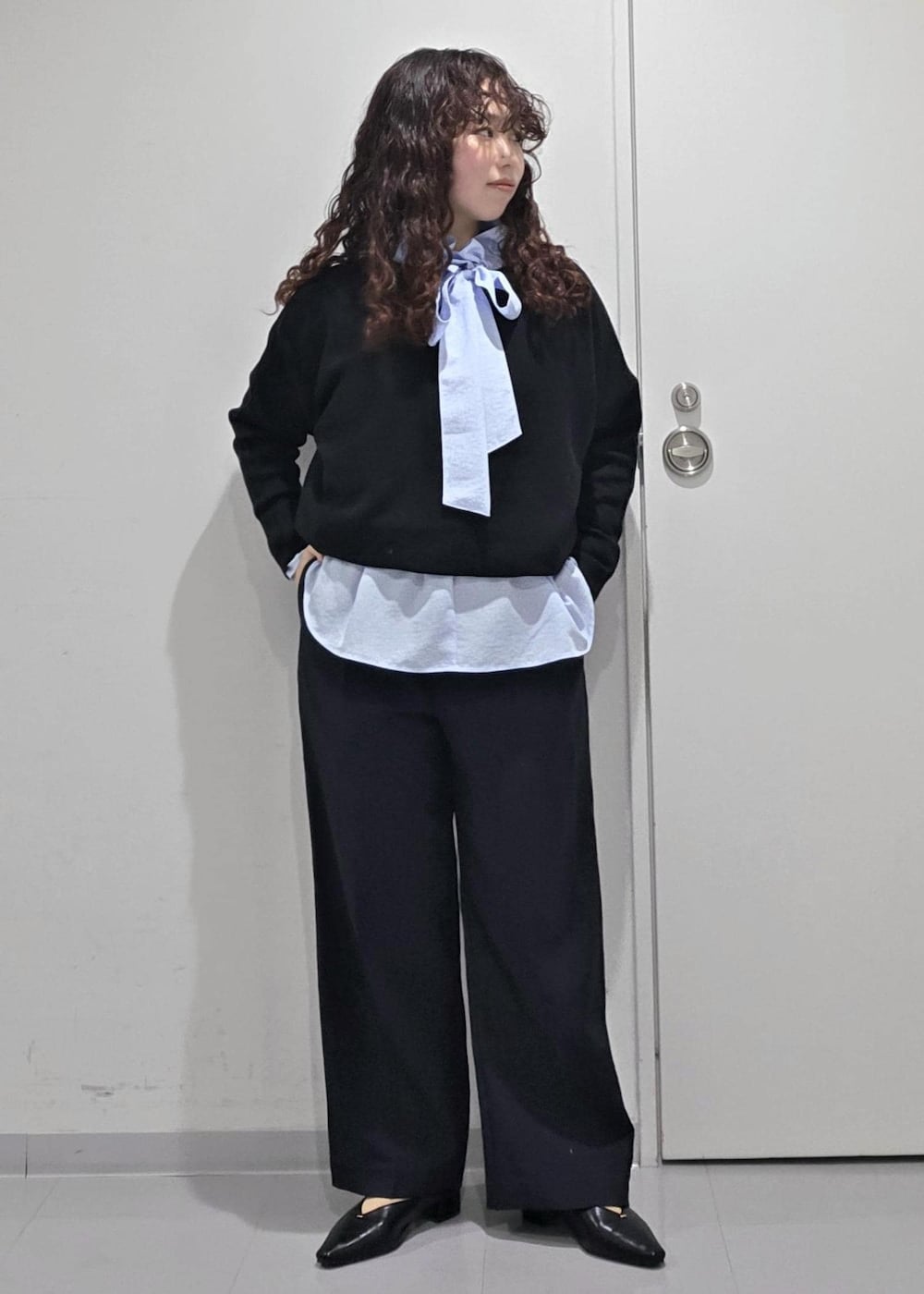 ブラック系のパンプス、ブラック系のニット/セーター、ブルー系のその他パンツを着用したレディースの冬コーディネートの3枚目の写真