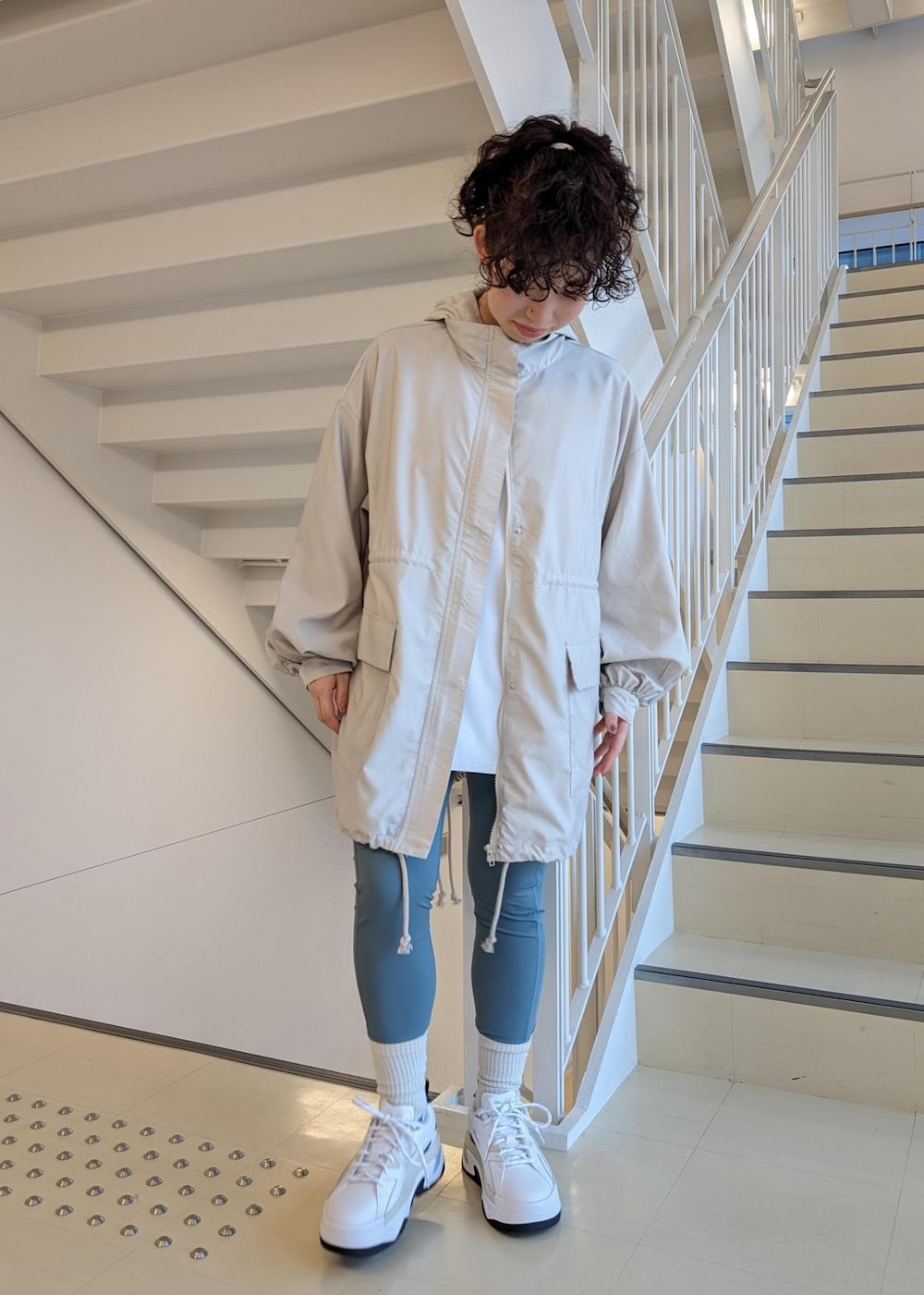 ホワイト系のスニーカー、ホワイト系のTシャツ/カットソー、ブルー系のレギンス/スパッツを着用したレディースの春コーディネートの2枚目の写真