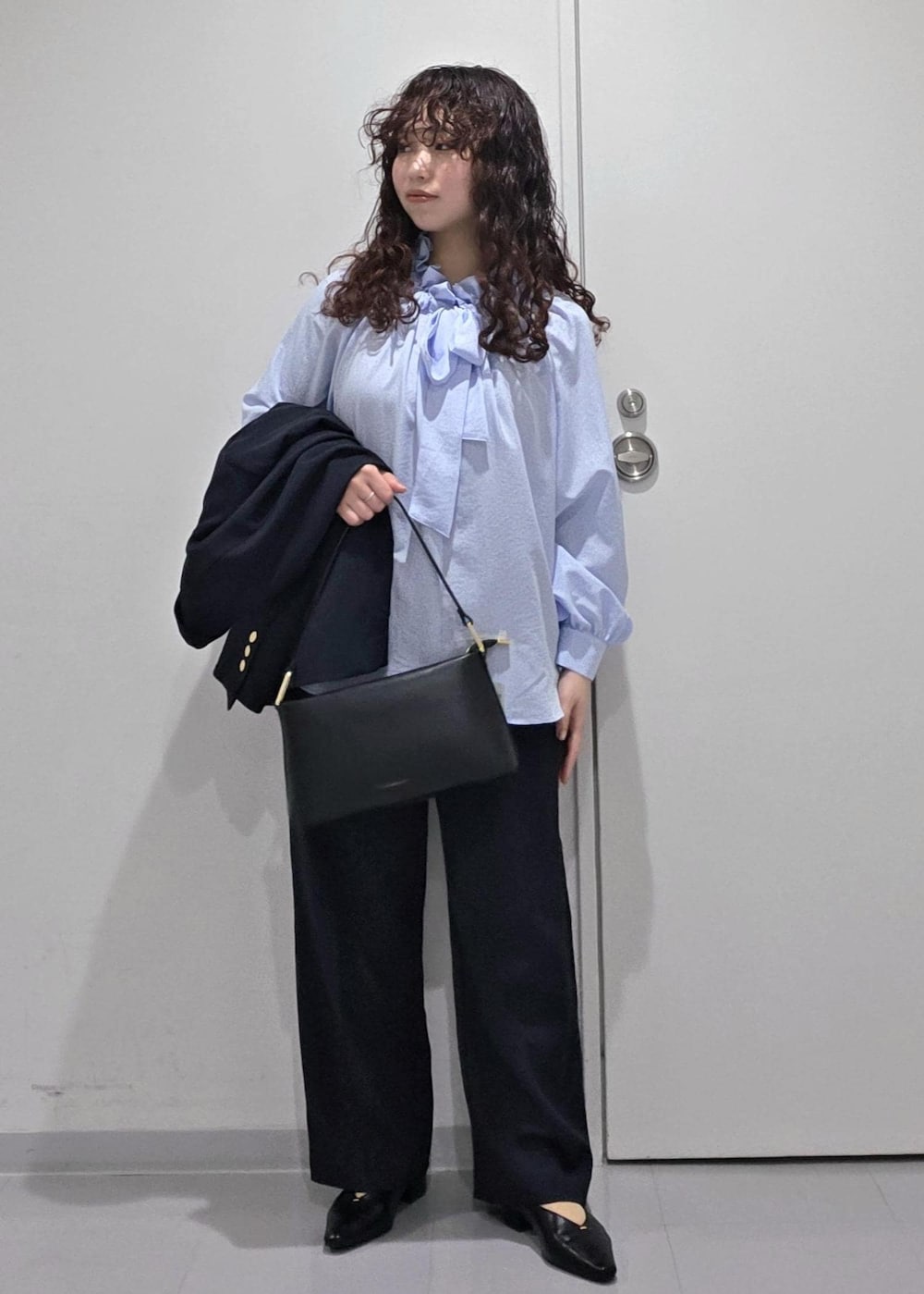 ブラック系のパンプス、ブルー系のシャツ/ブラウス、ブラック系のショルダーバッグを着用したレディースの冬コーディネートの6枚目の写真