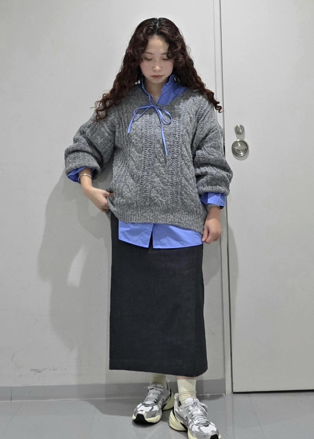グレー系のスカート、ブルー系のニット/セーター、ブルー系のシャツ/ブラウスを着用したレディースの冬コーディネートの4枚目の写真