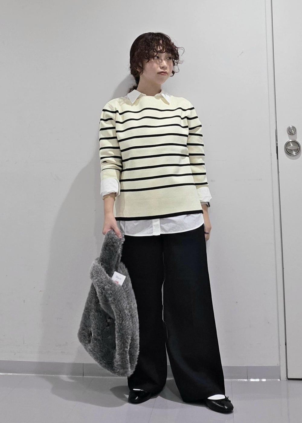 ホワイト系のシャツ/ブラウス、ホワイト系のニット/セーター、ブルー系のスラックスを着用したレディースの秋コーディネートの4枚目の写真