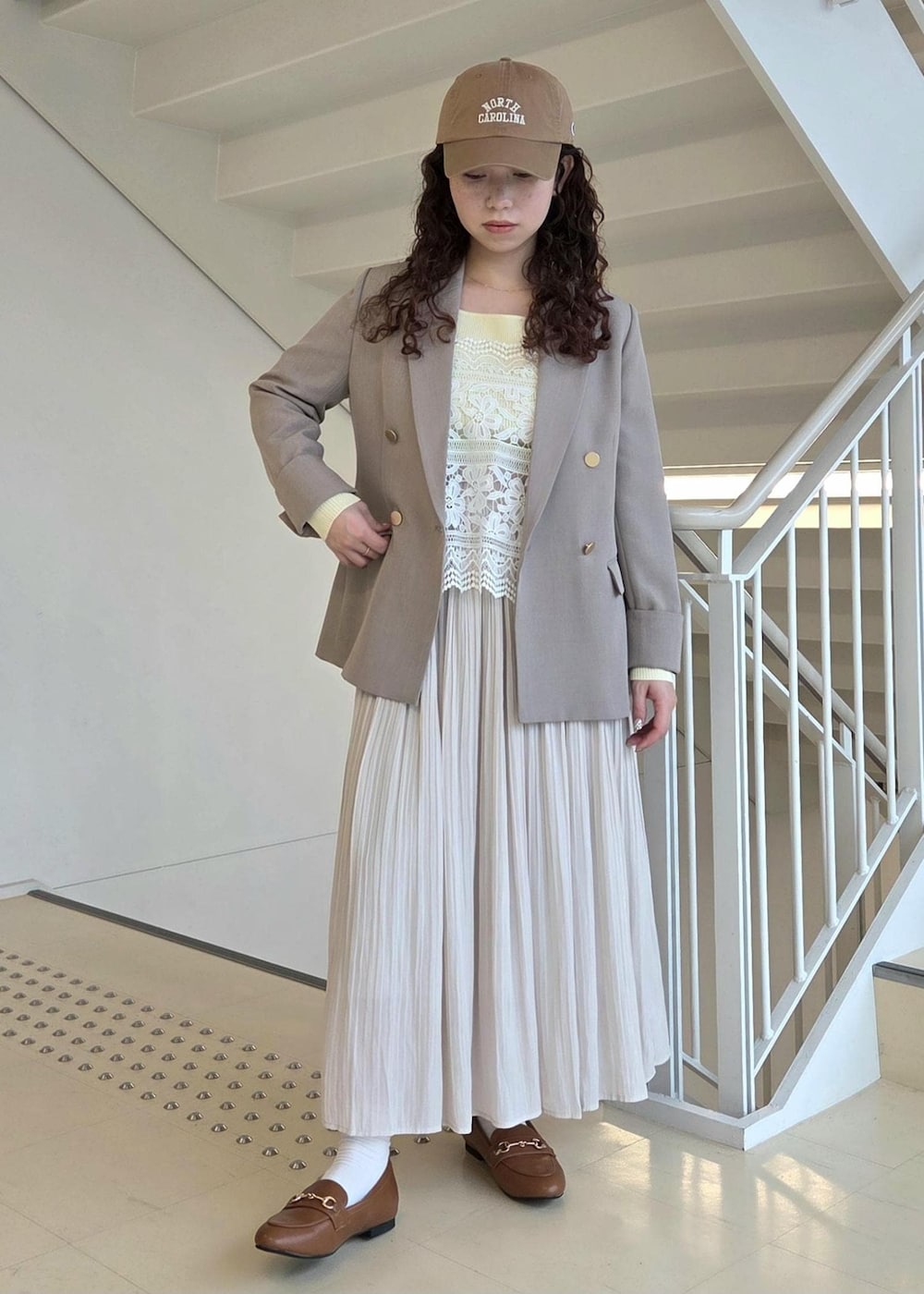 イエロー系のローファー、ベージュ系のテーラードジャケット、ベージュ系のニット/セーターを着用したレディースの春コーディネートの3枚目の写真