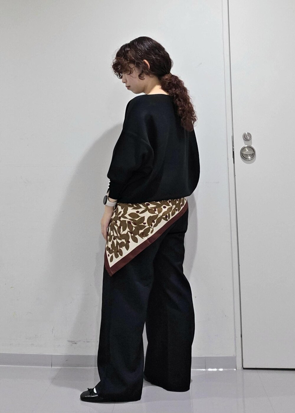 ブラウン系のニット/セーター、ブルー系のスラックス、ブラック系のバレエシューズを着用したレディースの秋コーディネートの5枚目の写真