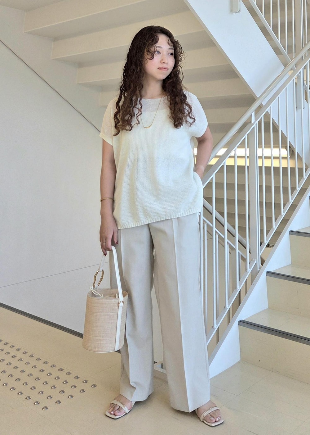 ベージュ系のその他パンツ、ホワイト系のハンドバッグ、ホワイト系のニット/セーターを着用したレディースの夏コーディネートの4枚目の写真