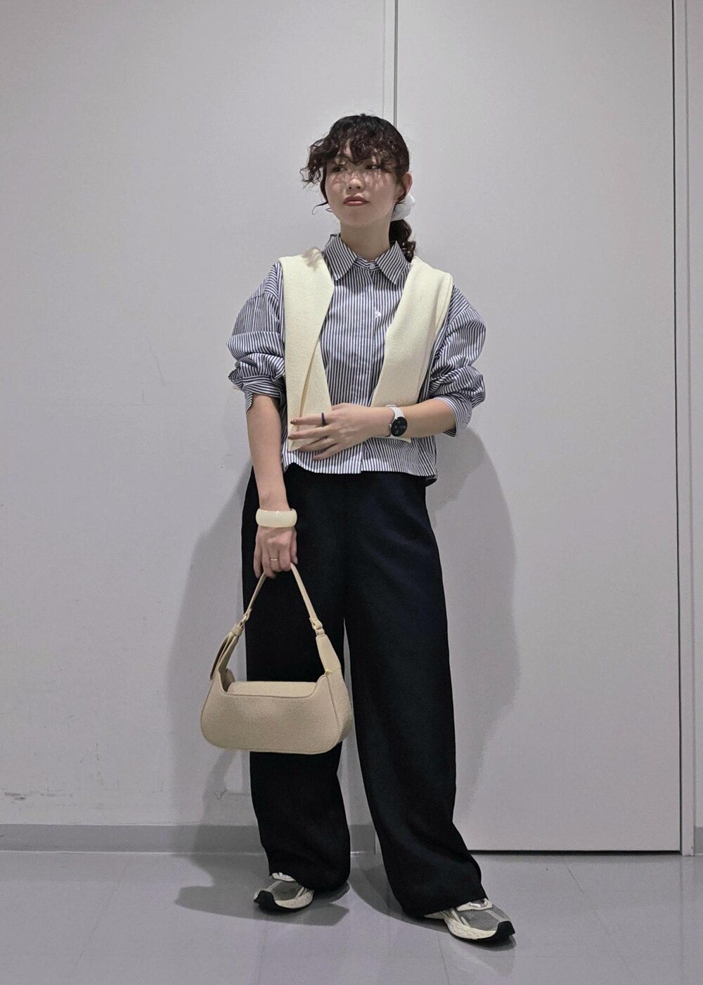 ブルー系のスラックス、ホワイト系のカーディガン/ボレロ、ブルー系のシャツ/ブラウスを着用したレディースの秋コーディネートの2枚目の写真