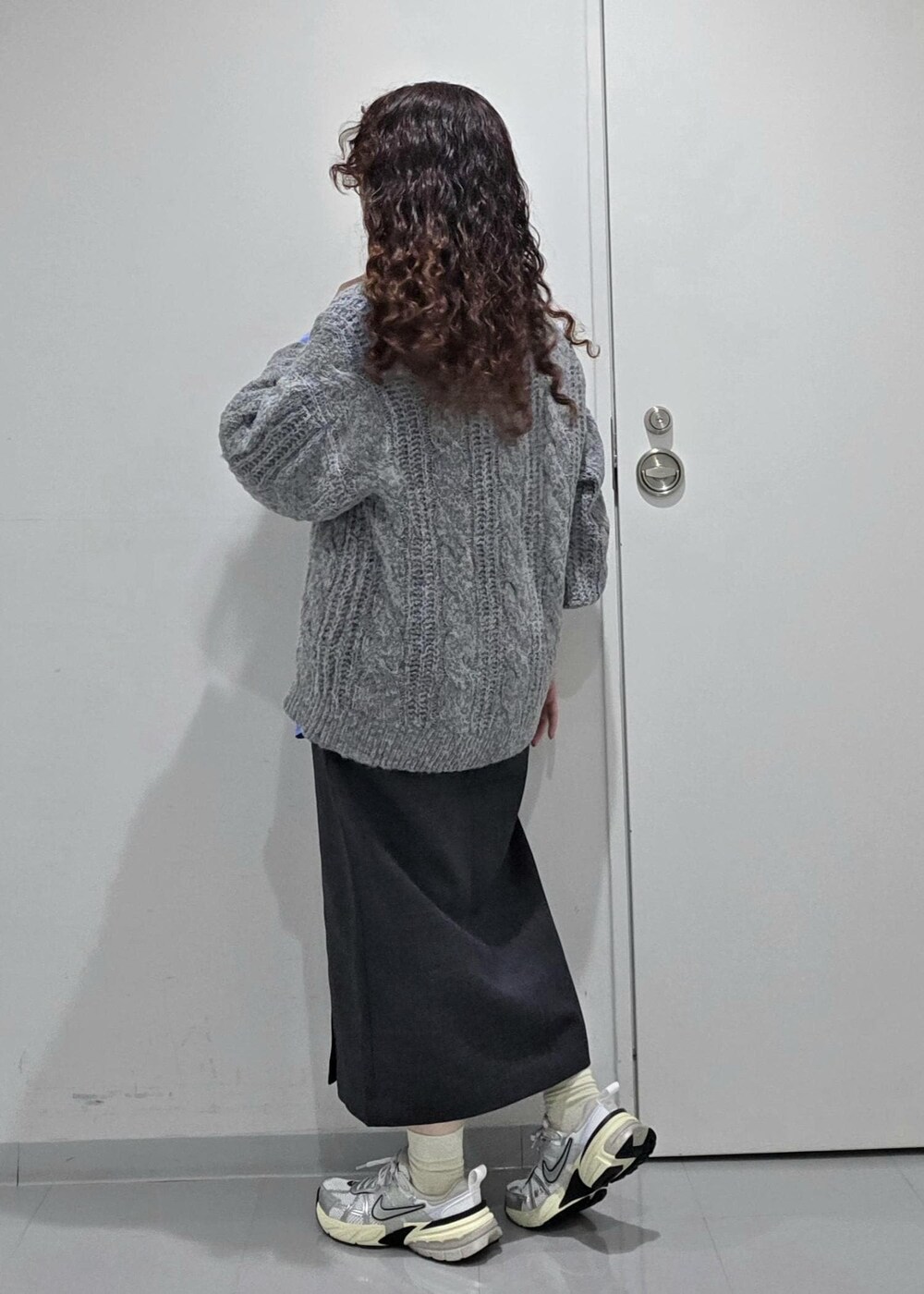 グレー系のスカート、ブルー系のニット/セーター、ブルー系のシャツ/ブラウスを着用したレディースの冬コーディネートの5枚目の写真