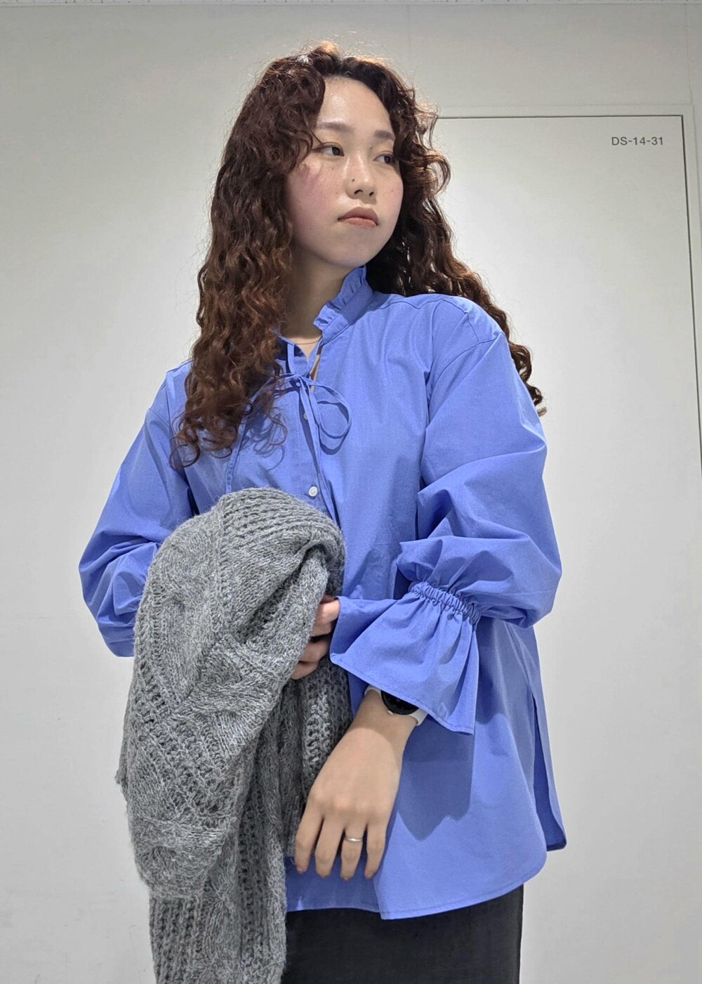 グレー系のスカート、ブルー系のニット/セーター、ブルー系のシャツ/ブラウスを着用したレディースの冬コーディネートの6枚目の写真