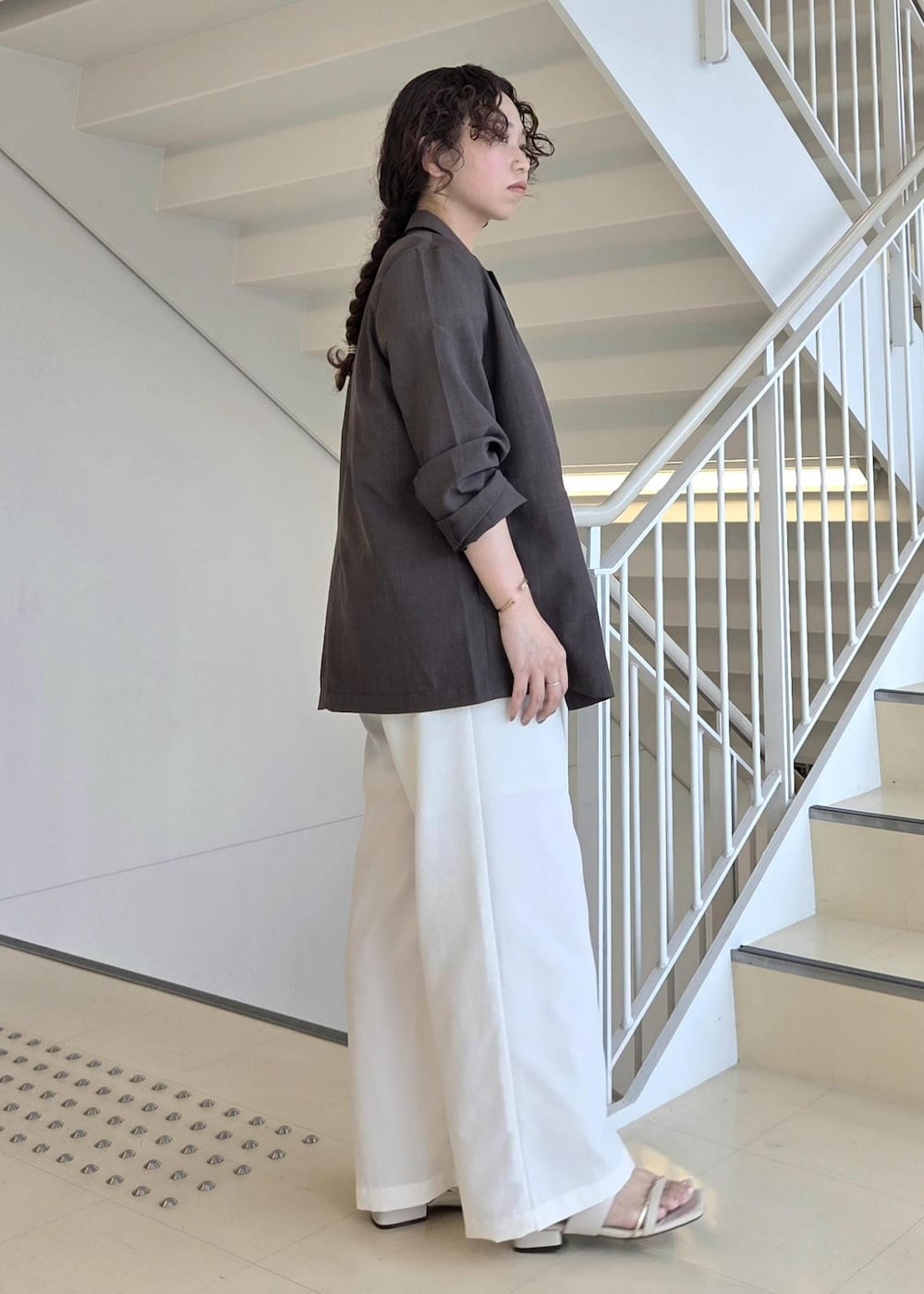 ブラウン系のテーラードジャケット、グレー系のTシャツ/カットソー、ホワイト系のその他パンツを着用したレディースの夏コーディネートの6枚目の写真