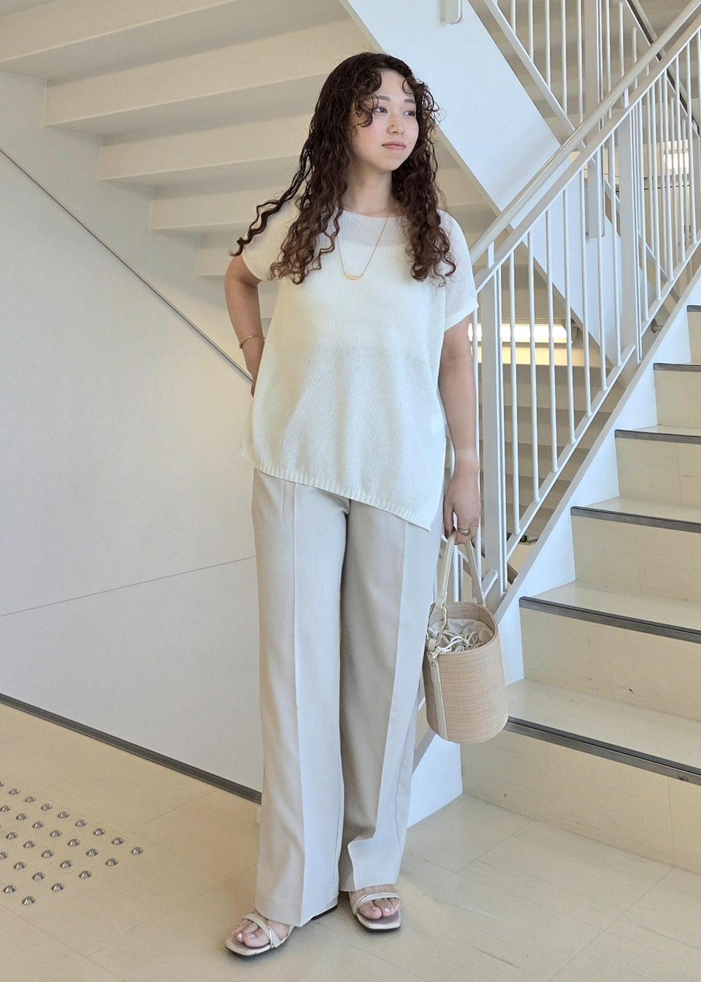 ベージュ系のその他パンツ、ホワイト系のハンドバッグ、ホワイト系のニット/セーターを着用したレディースの夏コーディネートの5枚目の写真