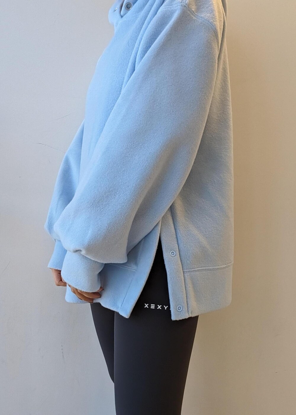 ブラック系のスニーカー、ブルー系のレッグウォーマー、グレー系のレギンス/スパッツを着用したレディースの冬コーディネートの6枚目の写真