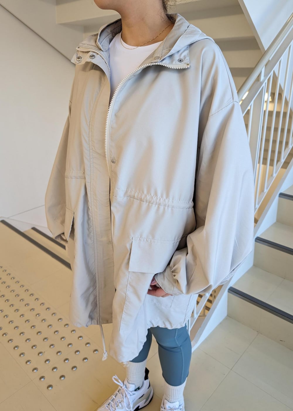 ホワイト系のスニーカー、ホワイト系のTシャツ/カットソー、ブルー系のレギンス/スパッツを着用したレディースの春コーディネートの7枚目の写真