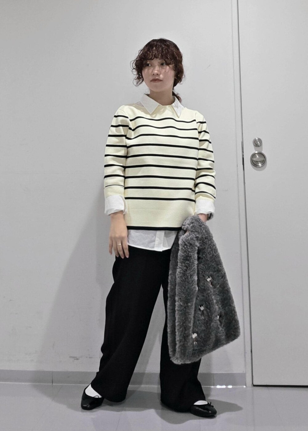 ホワイト系のシャツ/ブラウス、ホワイト系のニット/セーター、ブルー系のスラックスを着用したレディースの秋コーディネートの2枚目の写真