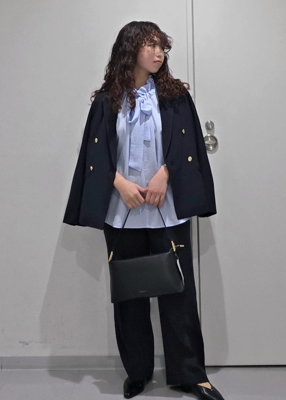 ブラック系のパンプス、ブルー系のシャツ/ブラウス、ブラック系のショルダーバッグを着用したレディースの冬コーディネートの3枚目の写真