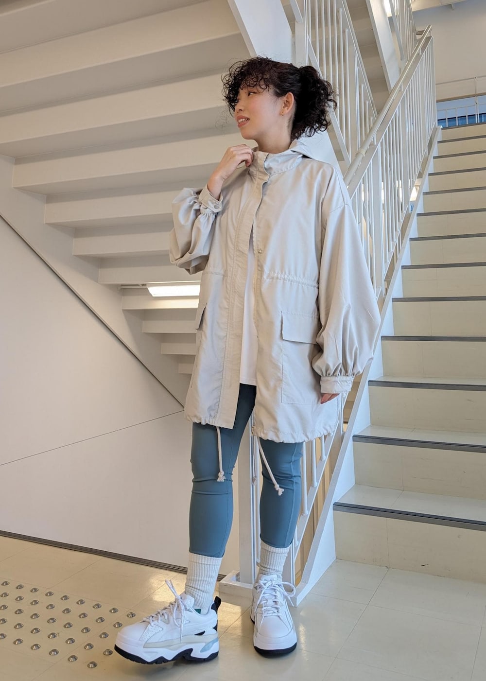 ホワイト系のスニーカー、ホワイト系のTシャツ/カットソー、ブルー系のレギンス/スパッツを着用したレディースの春コーディネートの4枚目の写真