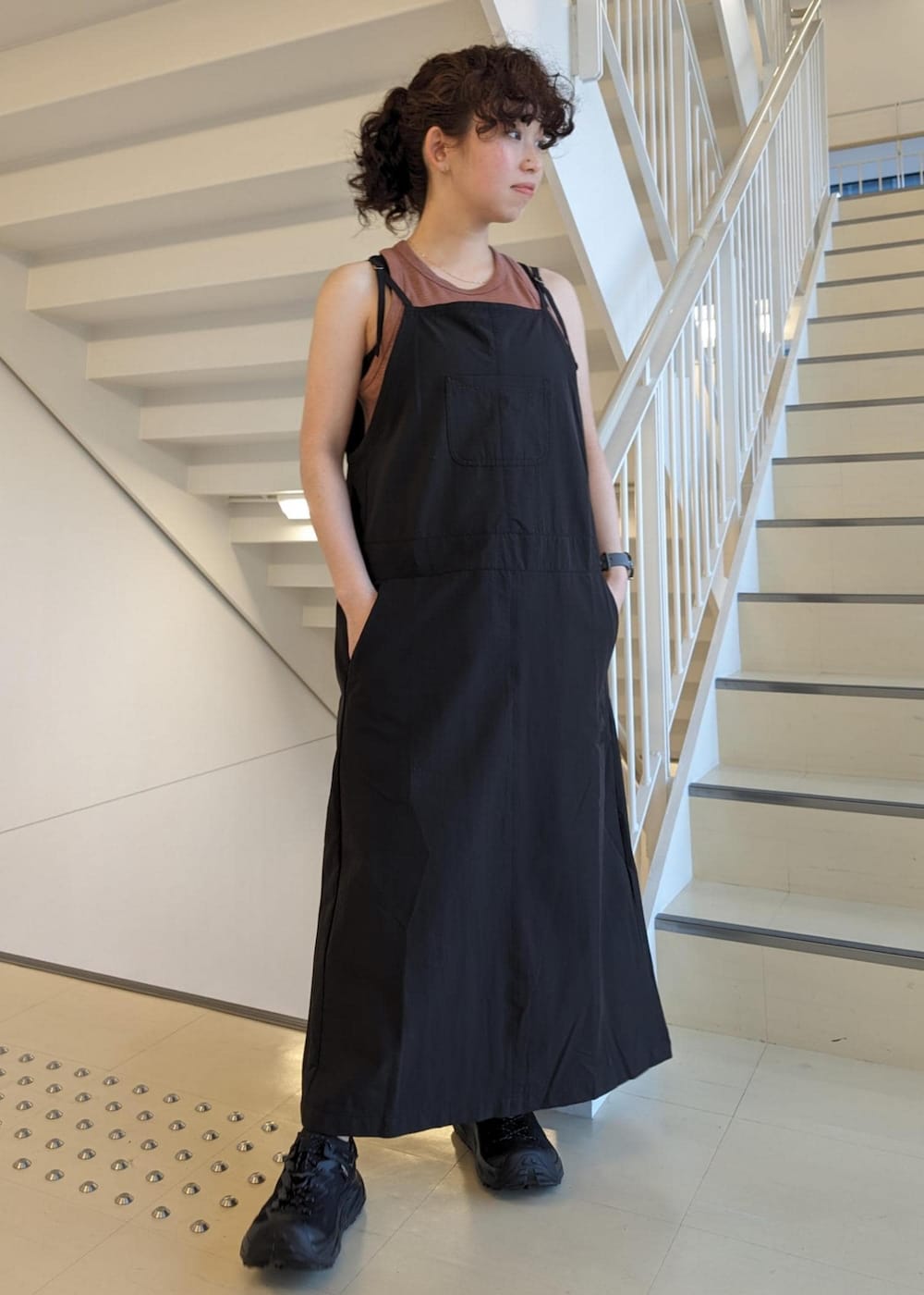 ブラック系のサンダル、ブラック系のワンピース、レッド系のタンクトップを着用したレディースの春コーディネートの2枚目の写真