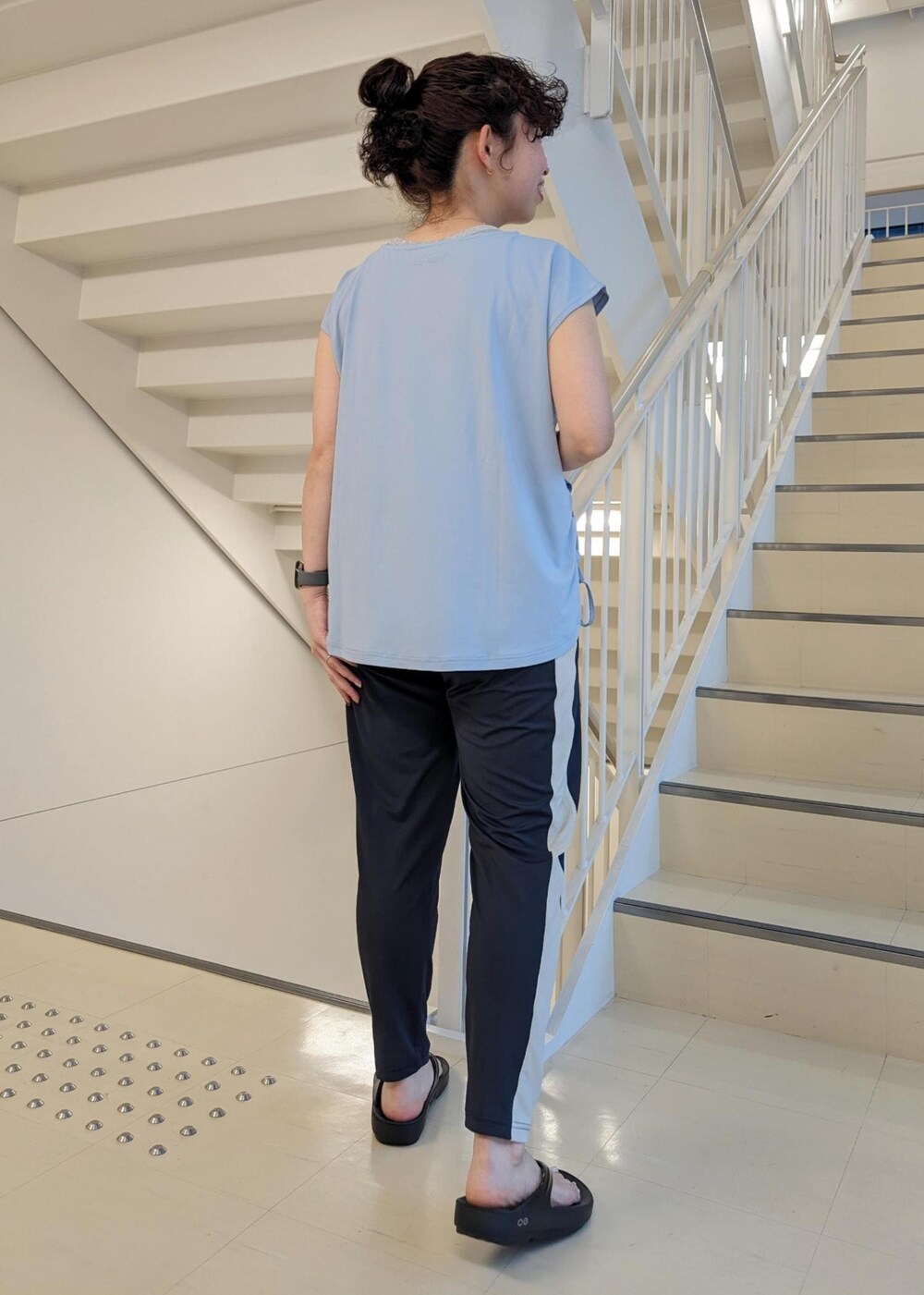 ブラック系のサンダル、ブルー系のTシャツ/カットソー、ブラック系のその他パンツを着用したレディースの春コーディネートの5枚目の写真