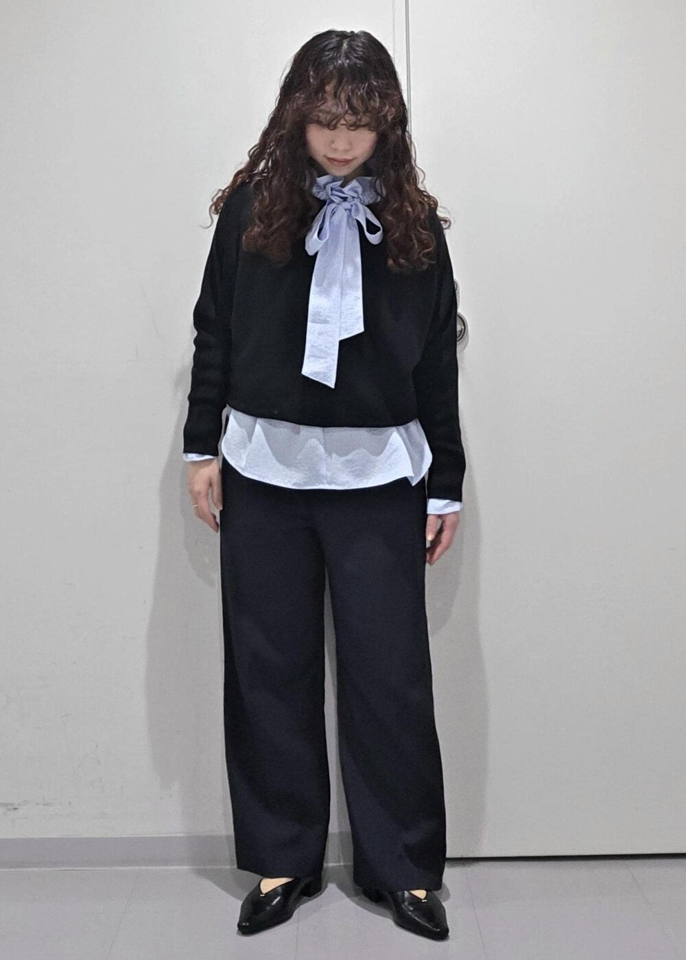 ブラック系のパンプス、ブラック系のニット/セーター、ブルー系のその他パンツを着用したレディースの冬コーディネートの5枚目の写真