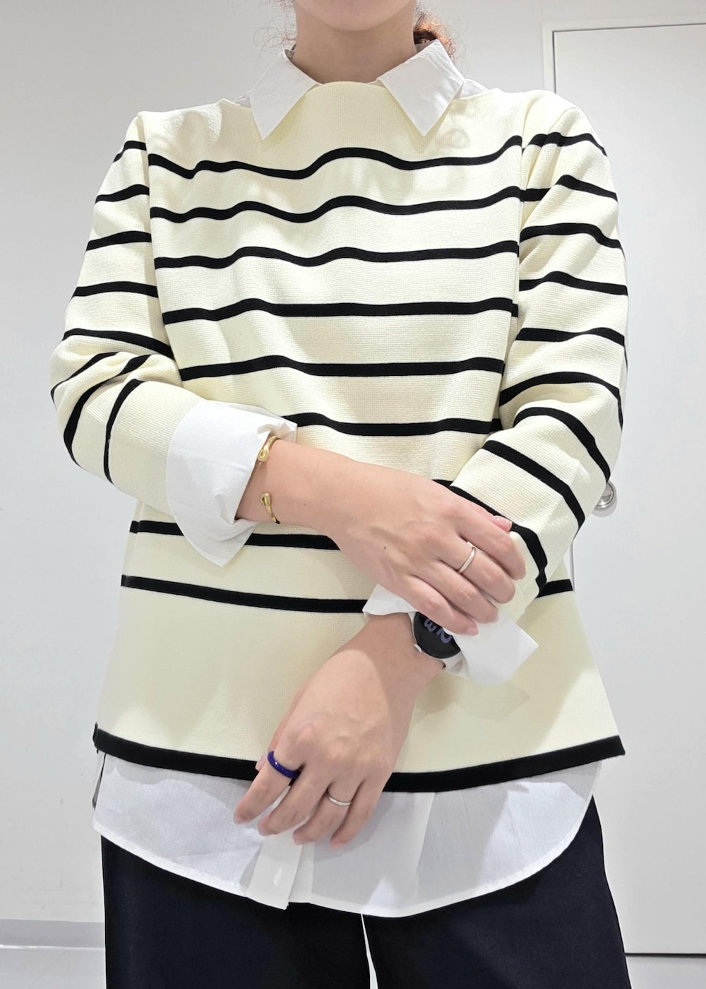 ホワイト系のシャツ/ブラウス、ホワイト系のニット/セーター、ブルー系のスラックスを着用したレディースの秋コーディネートの7枚目の写真