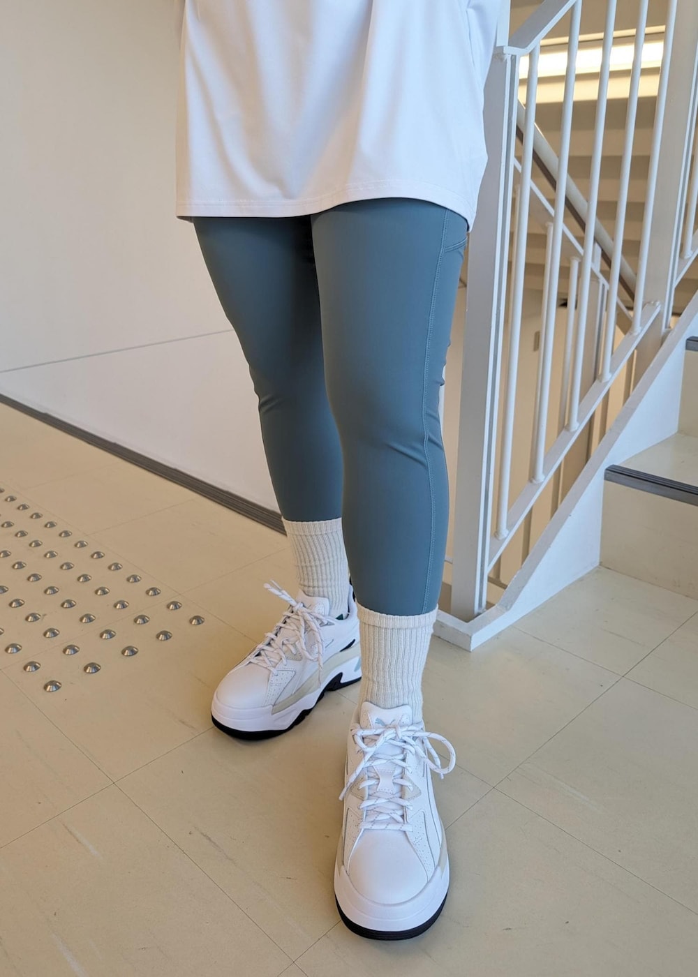 ホワイト系のスニーカー、ホワイト系のTシャツ/カットソー、ブルー系のレギンス/スパッツを着用したレディースの春コーディネートの6枚目の写真