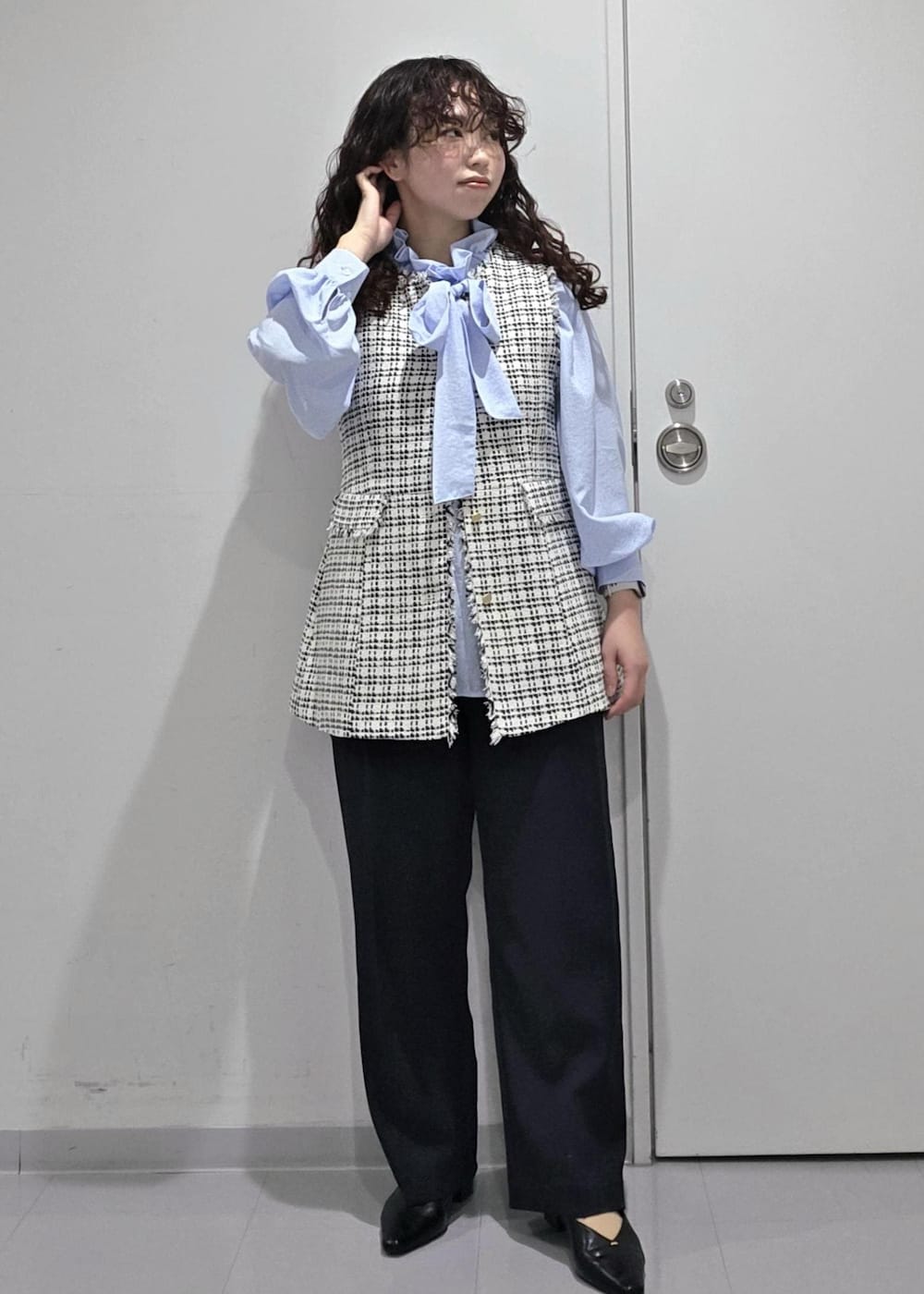 ブラック系のパンプス、ブルー系のその他パンツ、ブラック系のベストを着用したレディースの冬コーディネートの2枚目の写真