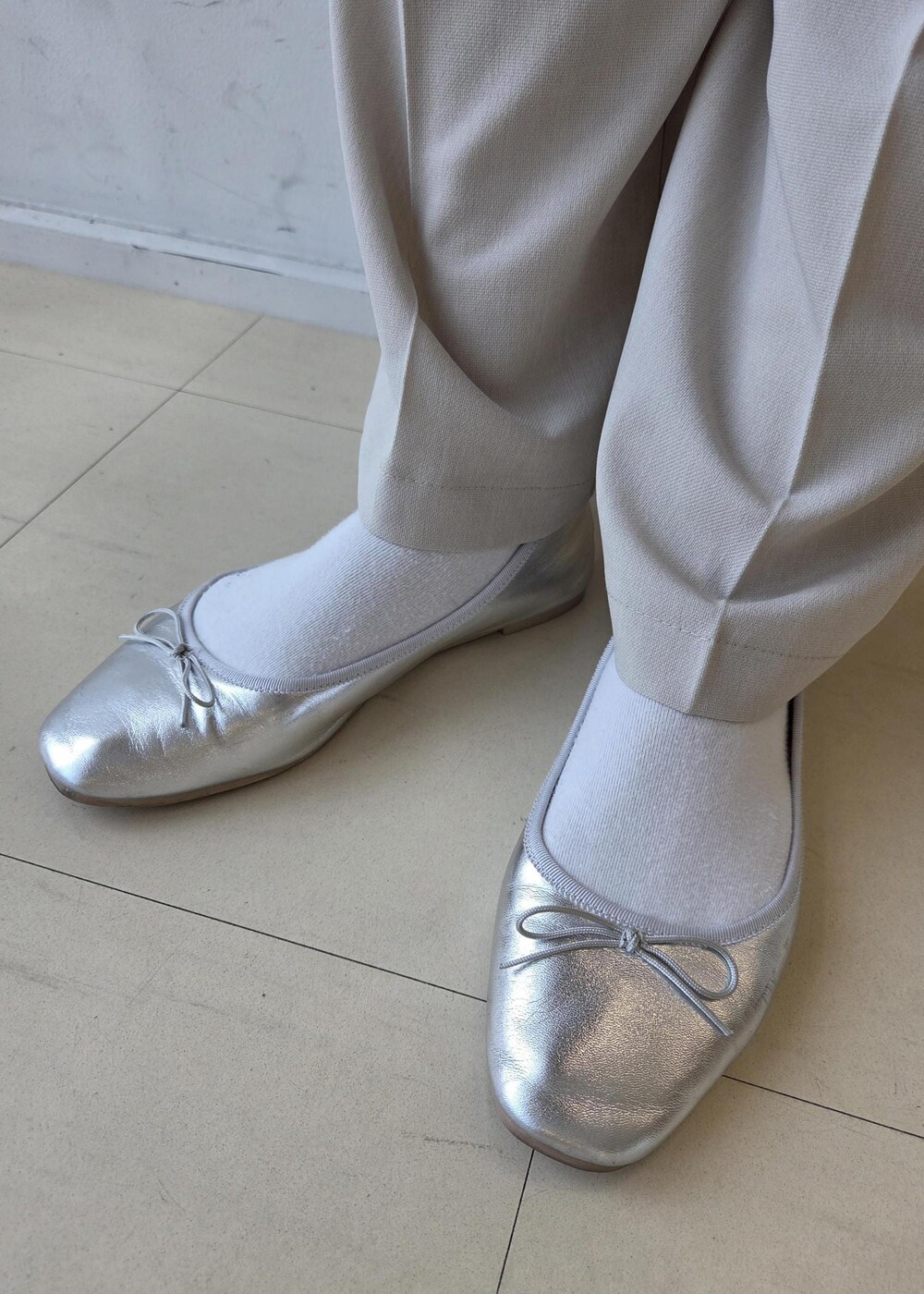 ホワイト系のカーディガン/ボレロ、ベージュ系のその他パンツ、シルバー系のバレエシューズを着用したレディースの春コーディネートの10枚目の写真