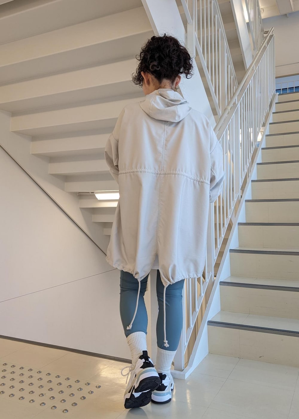 ホワイト系のスニーカー、ホワイト系のTシャツ/カットソー、ブルー系のレギンス/スパッツを着用したレディースの春コーディネートの6枚目の写真