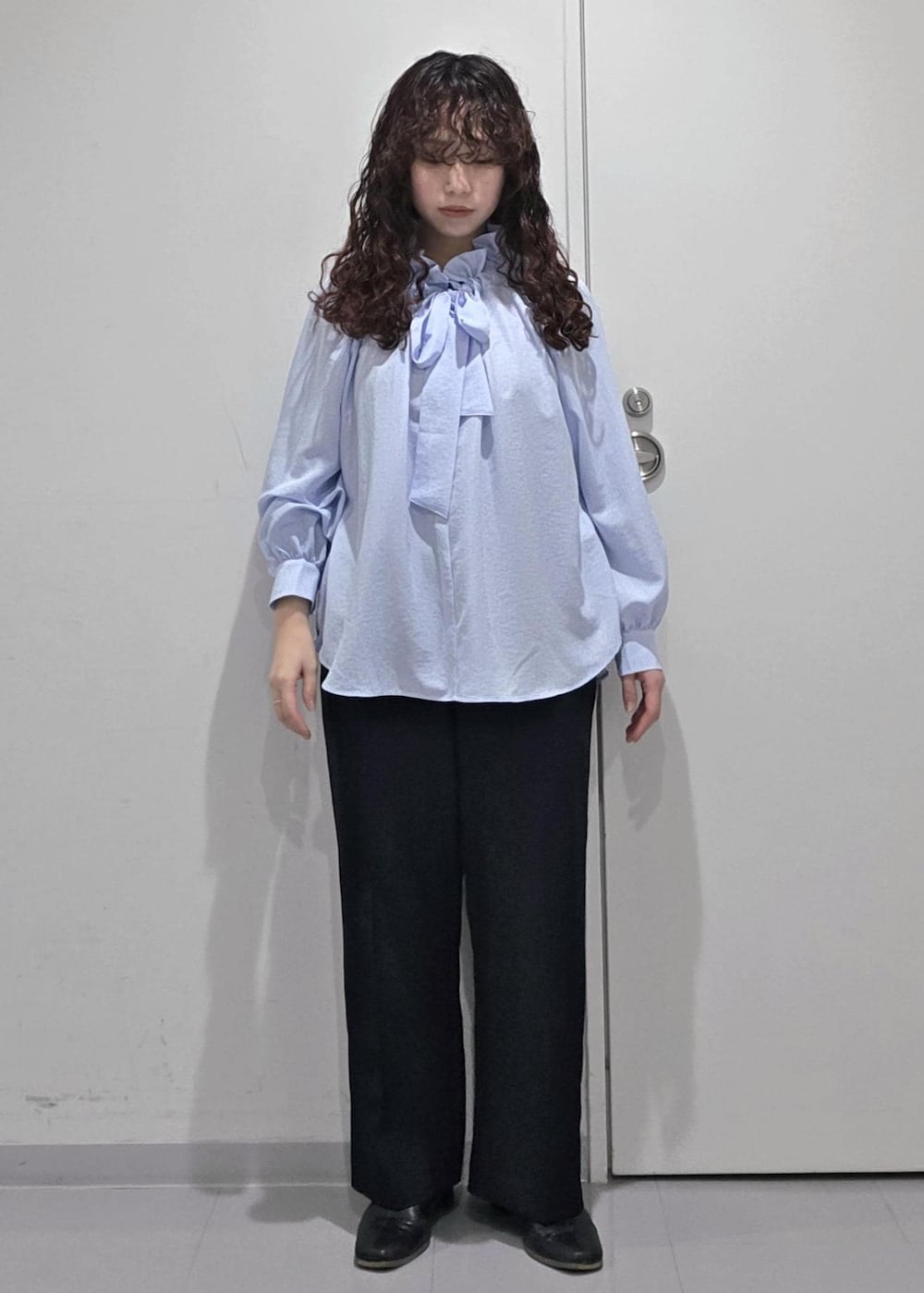 ブラック系のパンプス、ブルー系のシャツ/ブラウス、ブラック系のショルダーバッグを着用したレディースの冬コーディネートの8枚目の写真