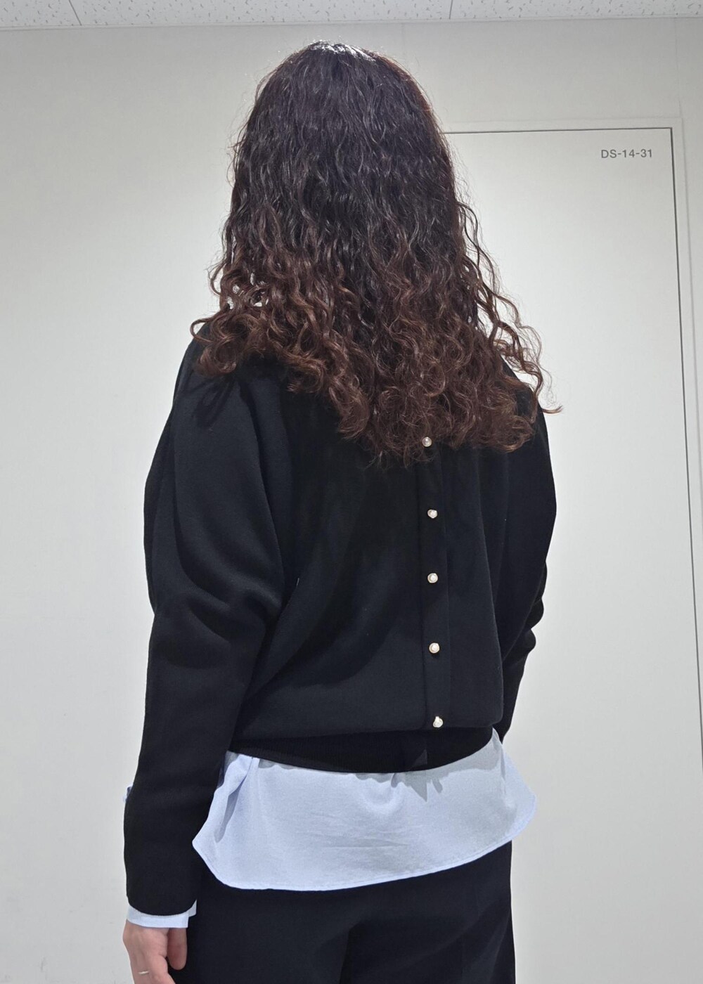 ブラック系のパンプス、ブラック系のニット/セーター、ブルー系のその他パンツを着用したレディースの冬コーディネートの8枚目の写真