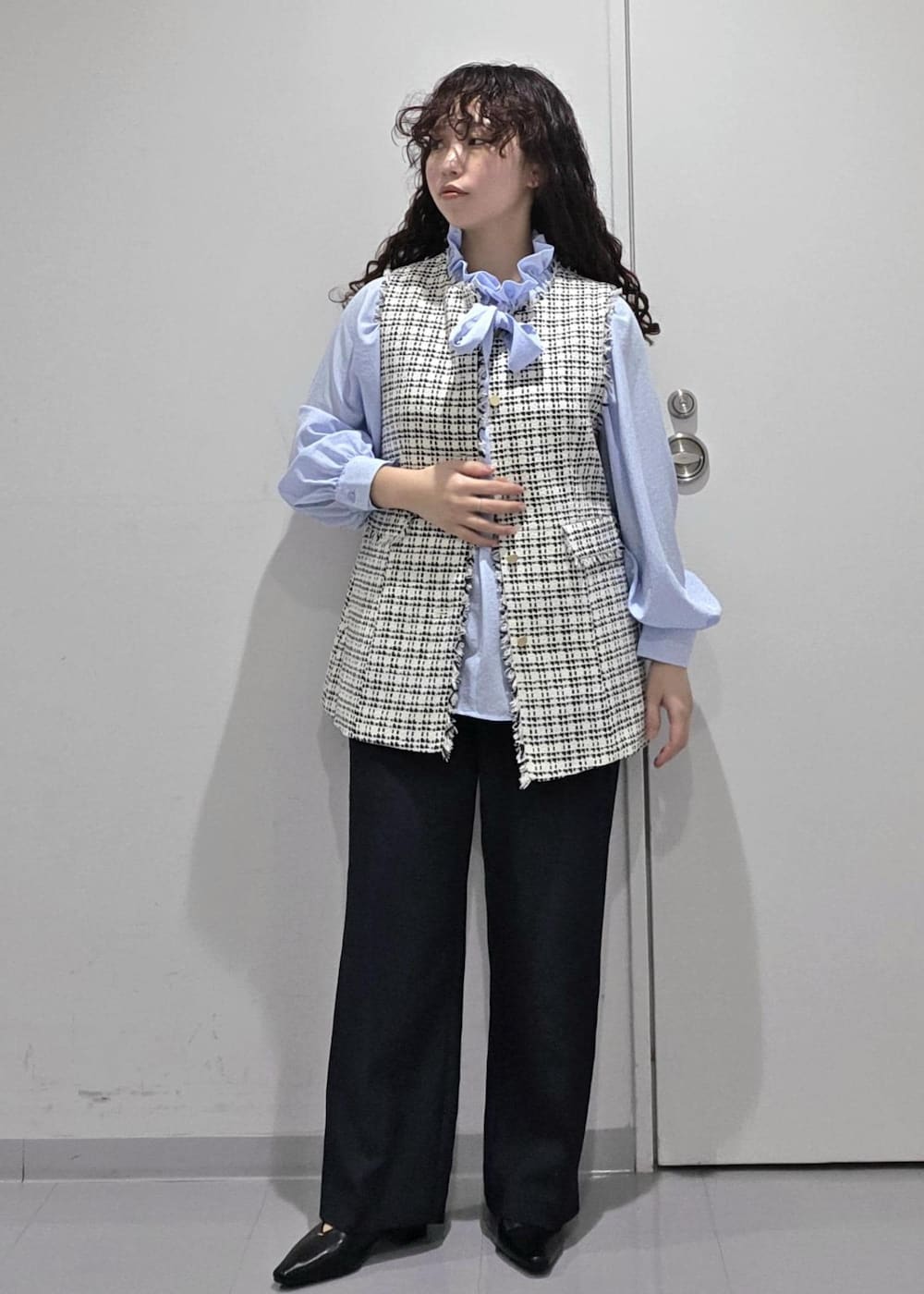 ブラック系のパンプス、ブルー系のその他パンツ、ブラック系のベストを着用したレディースの冬コーディネートの3枚目の写真