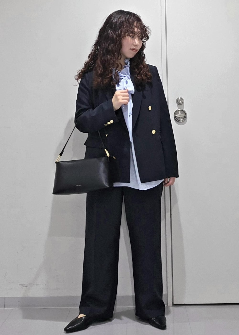 ブラック系のパンプス、ブルー系のシャツ/ブラウス、ブラック系のショルダーバッグを着用したレディースの冬コーディネートの5枚目の写真