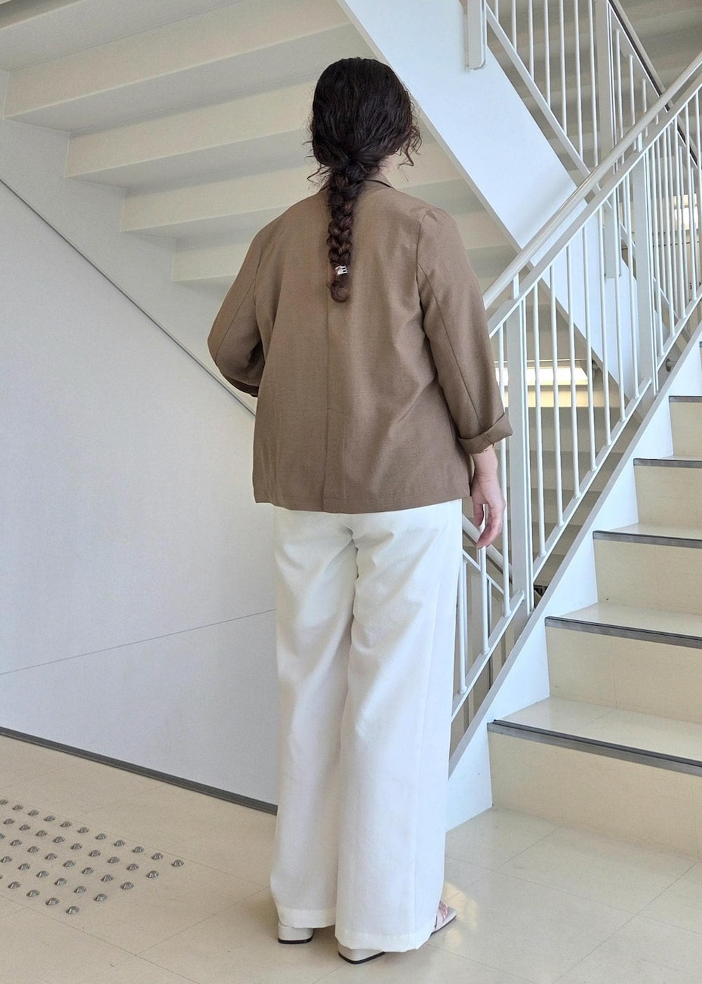 グレー系のTシャツ/カットソー、イエロー系のテーラードジャケット、ホワイト系のその他パンツを着用したレディースの夏コーディネートの6枚目の写真
