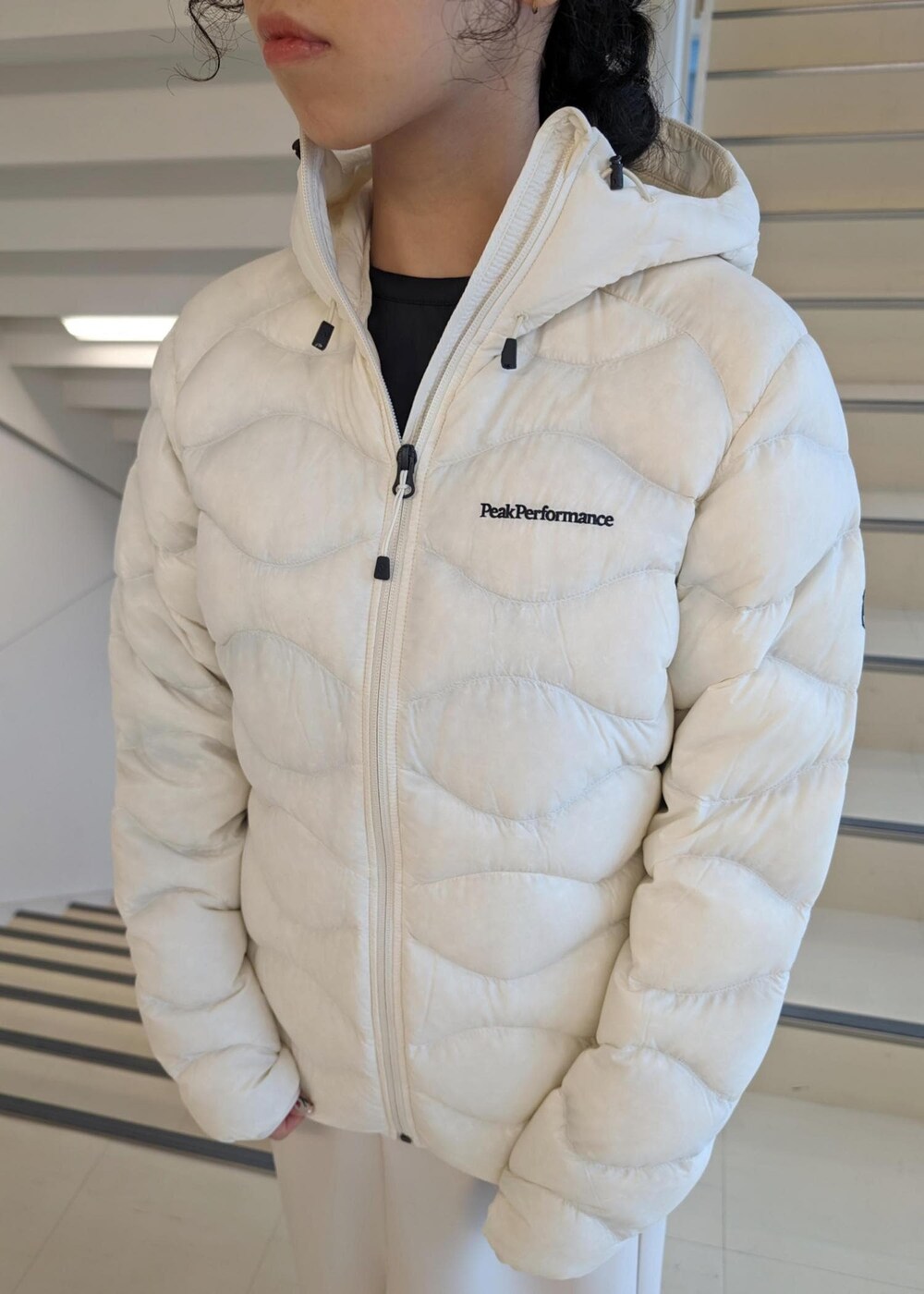 ホワイト系のスカート、ホワイト系のダウンジャケット/コート、ブラック系のTシャツ/カットソーを着用したレディースの冬コーディネートの6枚目の写真