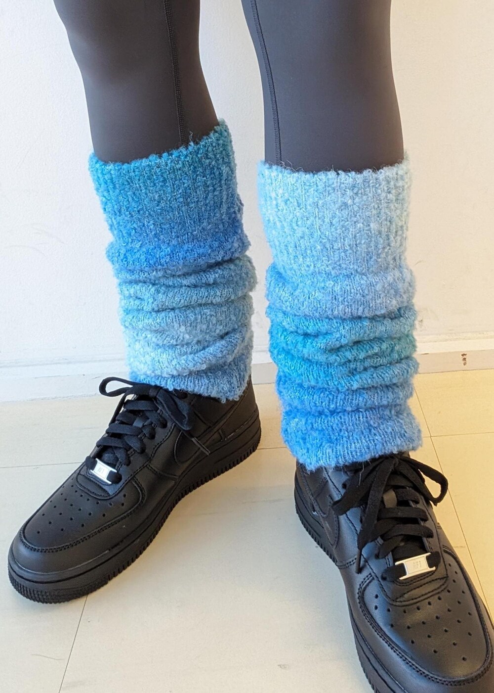 ブラック系のスニーカー、ブルー系のレッグウォーマー、グレー系のレギンス/スパッツを着用したレディースの冬コーディネートの7枚目の写真