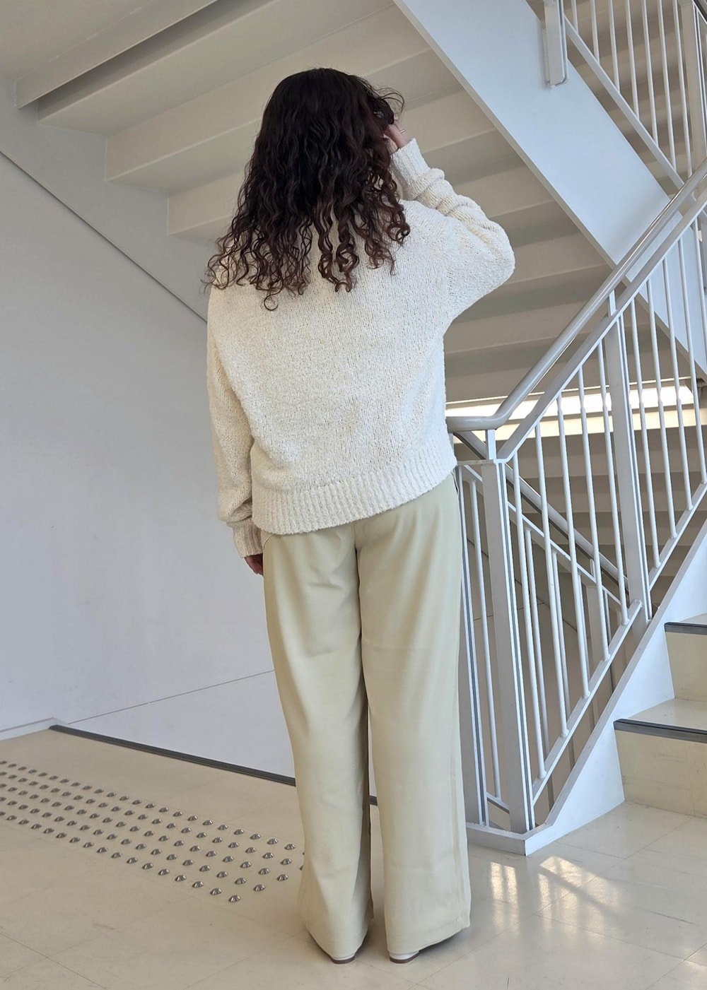 ホワイト系のローファー、ベージュ系のニット/セーター、イエロー系のその他パンツを着用したレディースの冬コーディネートの6枚目の写真