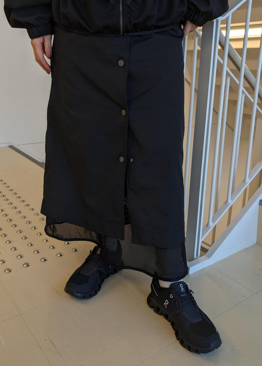 レッド系のTシャツ/カットソー、ブラック系のスニーカー、ブラック系のブルゾンを着用したレディースの春コーディネートの7枚目の写真