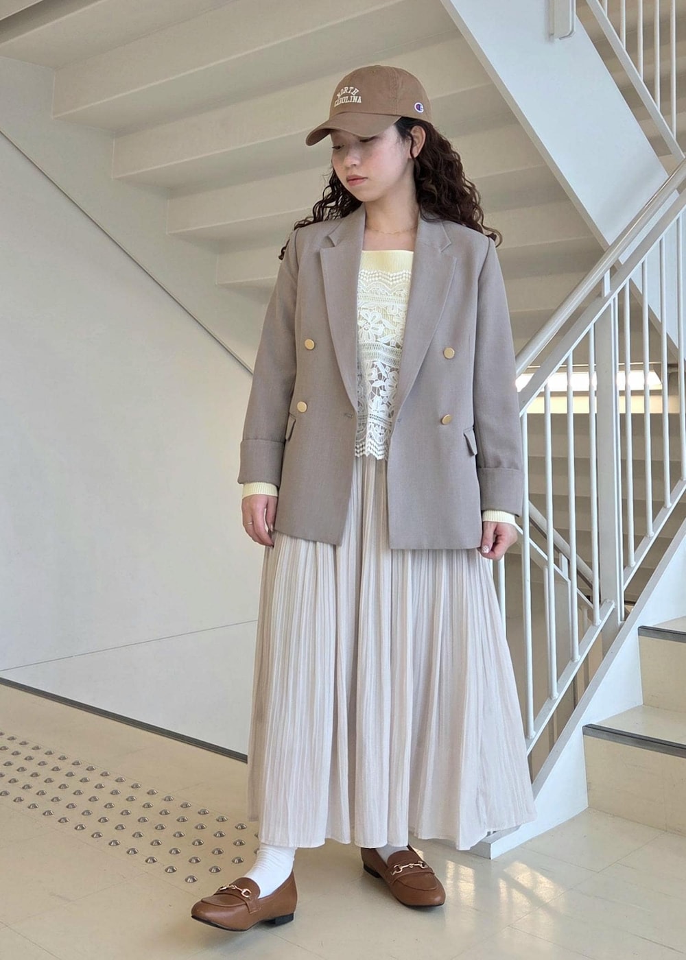 イエロー系のローファー、ベージュ系のテーラードジャケット、ベージュ系のニット/セーターを着用したレディースの春コーディネートの4枚目の写真