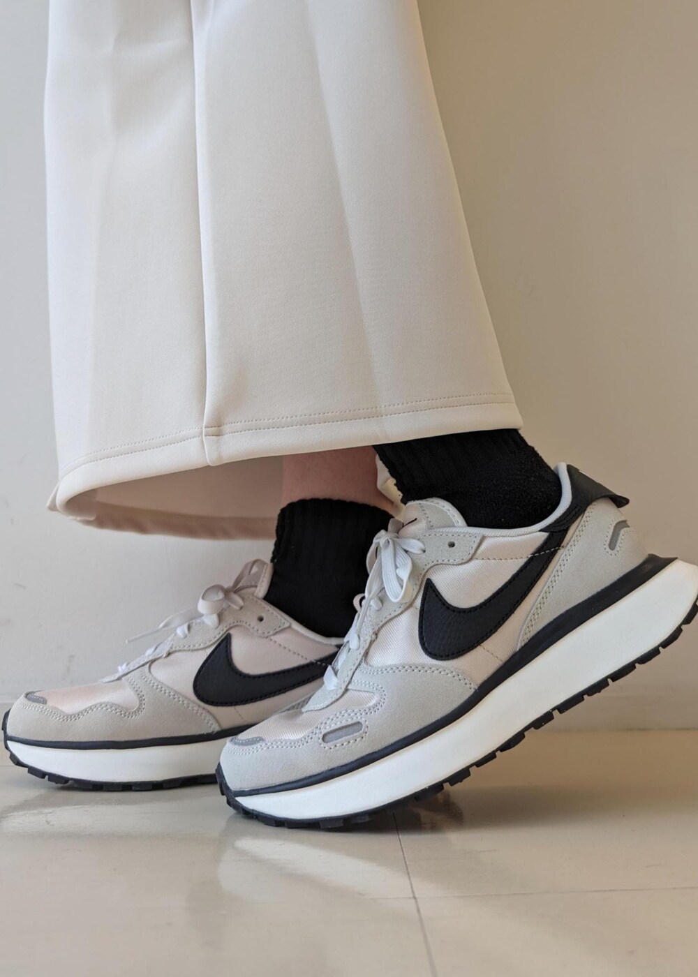 ホワイト系のスカート、ホワイト系のダウンジャケット/コート、ブラック系のTシャツ/カットソーを着用したレディースの冬コーディネートの10枚目の写真