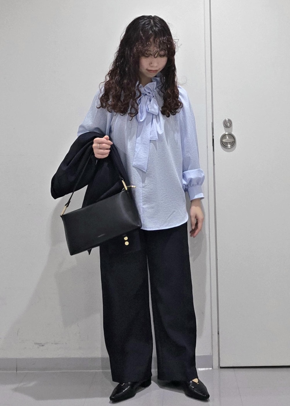 ブラック系のパンプス、ブルー系のシャツ/ブラウス、ブラック系のショルダーバッグを着用したレディースの冬コーディネートの9枚目の写真