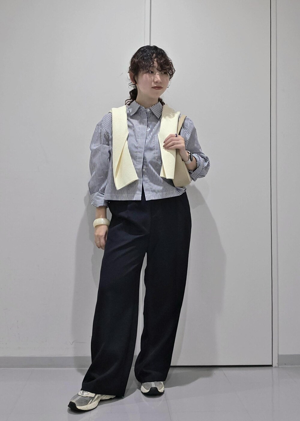 ブルー系のスラックス、ホワイト系のカーディガン/ボレロ、ブルー系のシャツ/ブラウスを着用したレディースの秋コーディネートの5枚目の写真