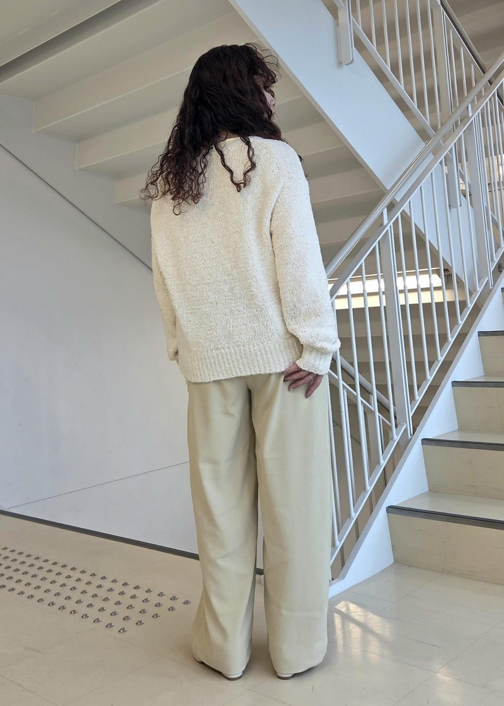 ホワイト系のローファー、ベージュ系のニット/セーター、イエロー系のその他パンツを着用したレディースの冬コーディネートの7枚目の写真